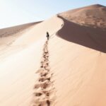 A lone traveler walks on the stunning sand dunes in Hardap Region, Namibia.